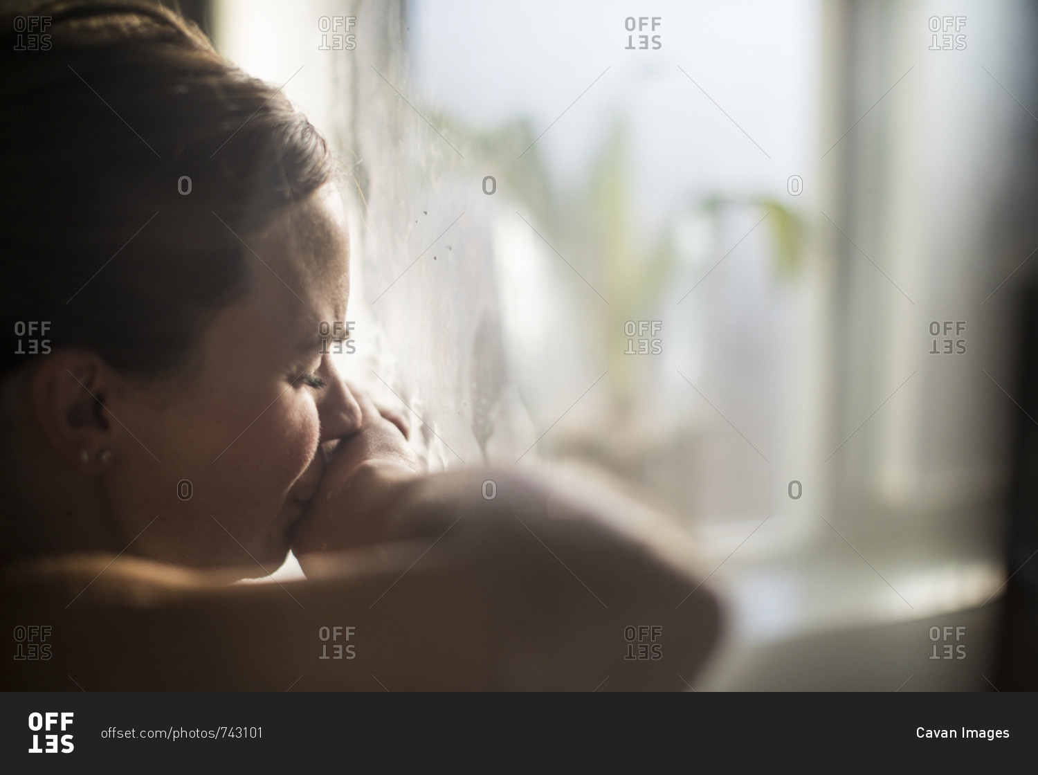 Close-up of pregnant woman with eyes closed in labor at home by window