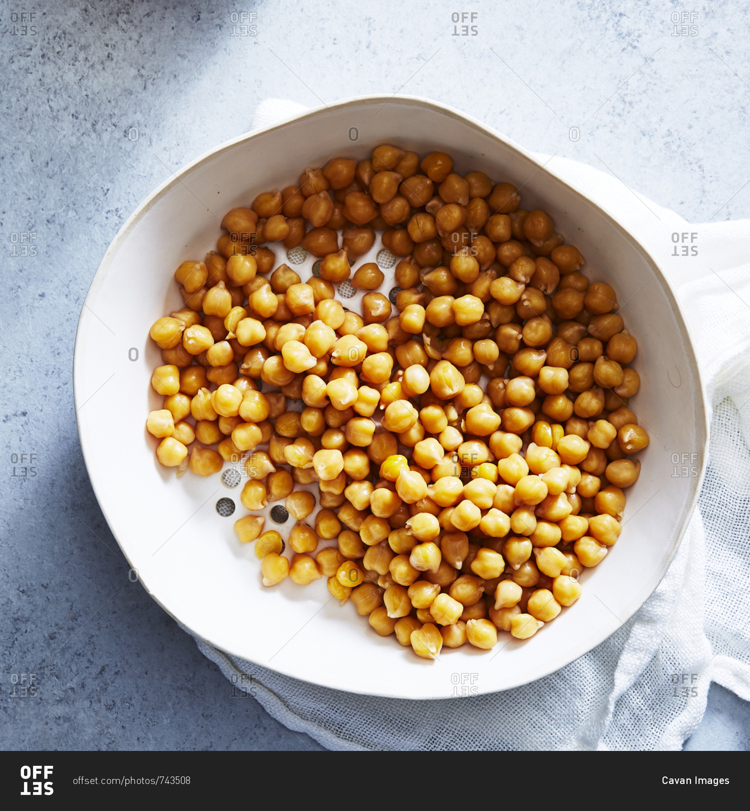 Overhead view of chick-peas in bowl with napkin on table