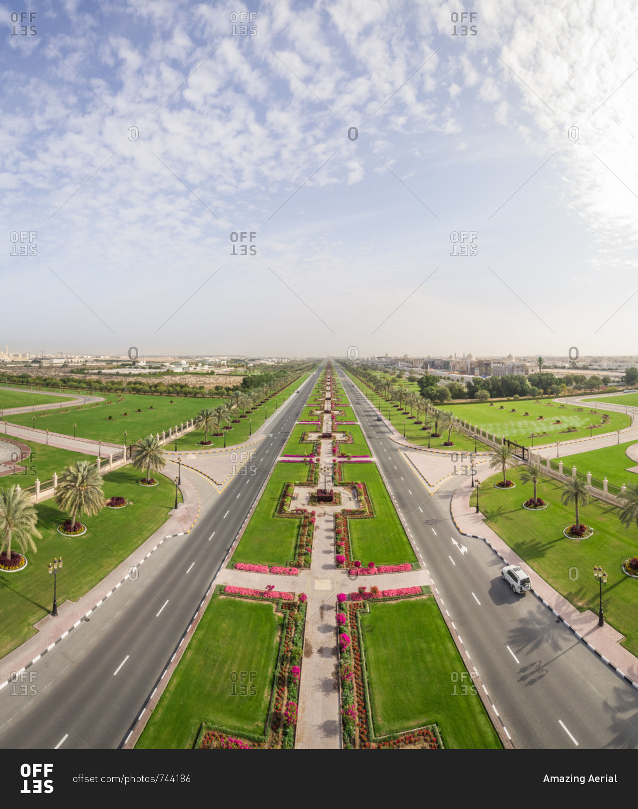 Aerial view of long road and flower beds in University City, Sharjah, UAE.