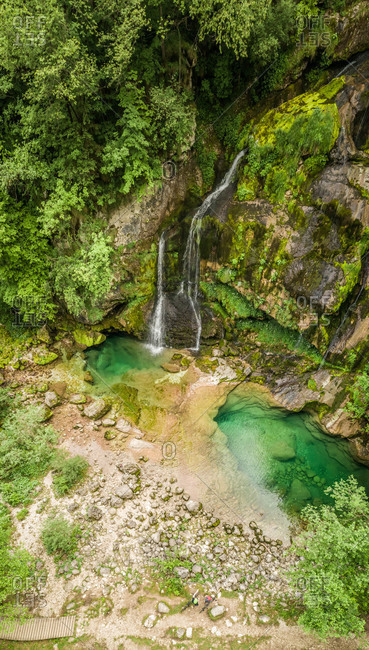 Aerial view of cyclists at Virje waterfall in Soca valley, Slovenia.