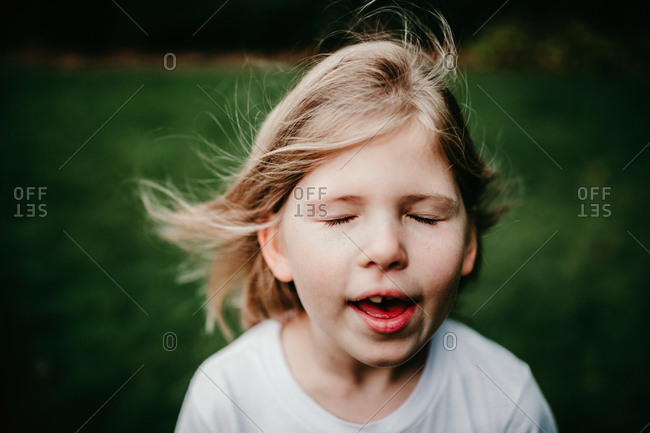 Little girl singing and feeling the breeze