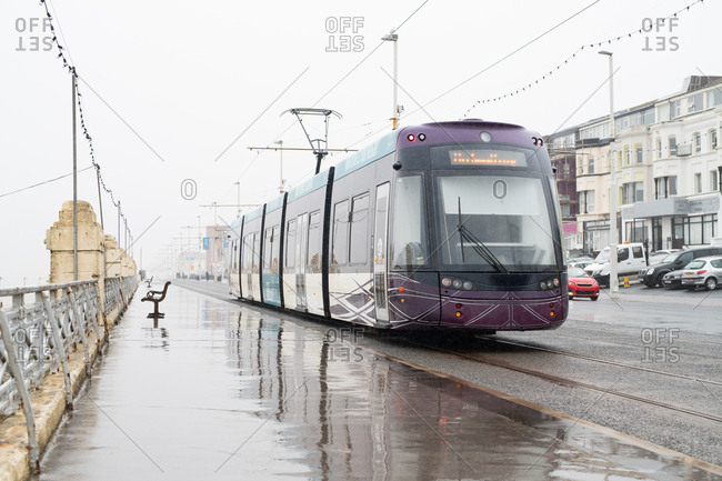 Light rail train in coastal city on a rainy day