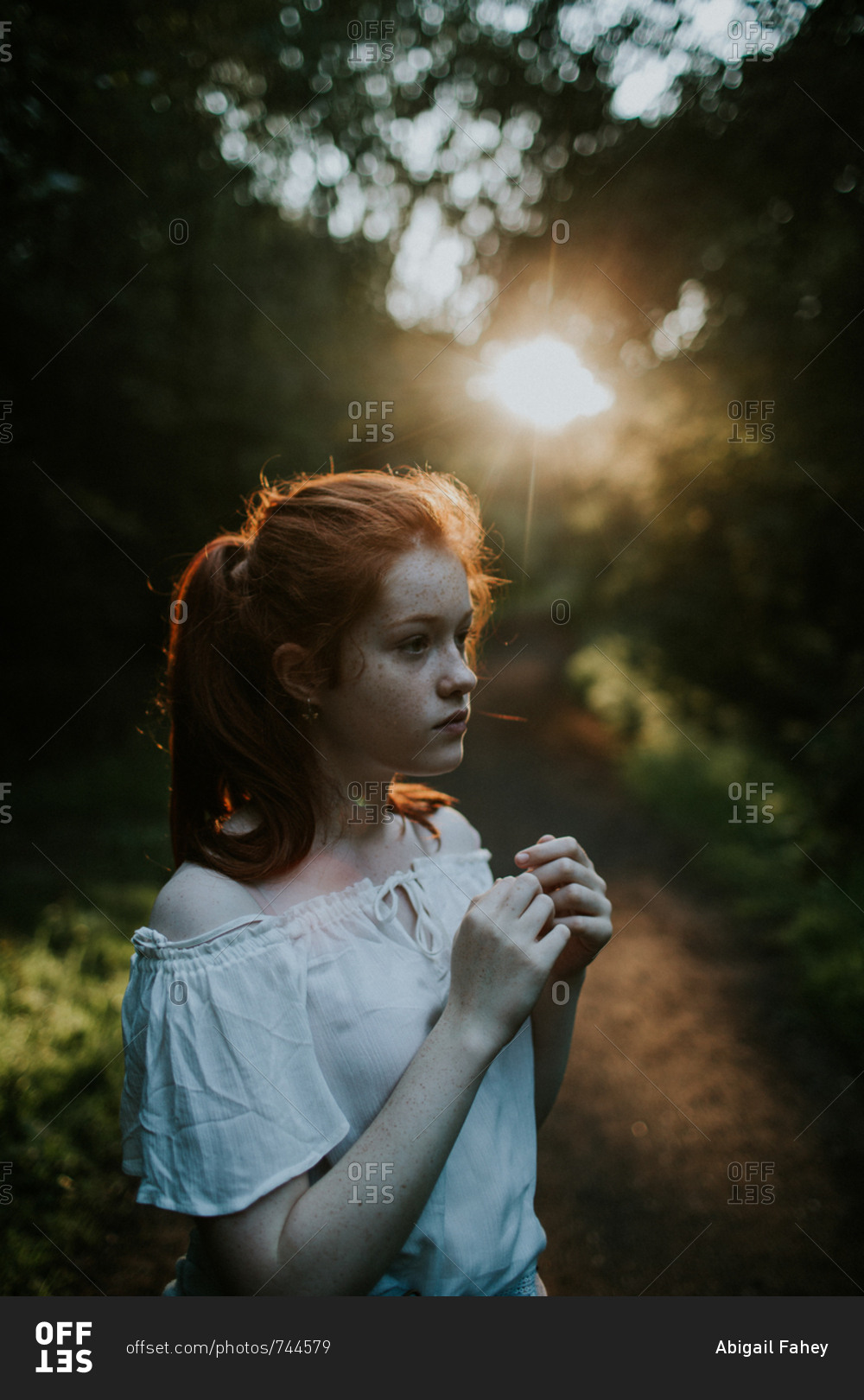 Ginger girl wearing off-shoulder blouse at sunset