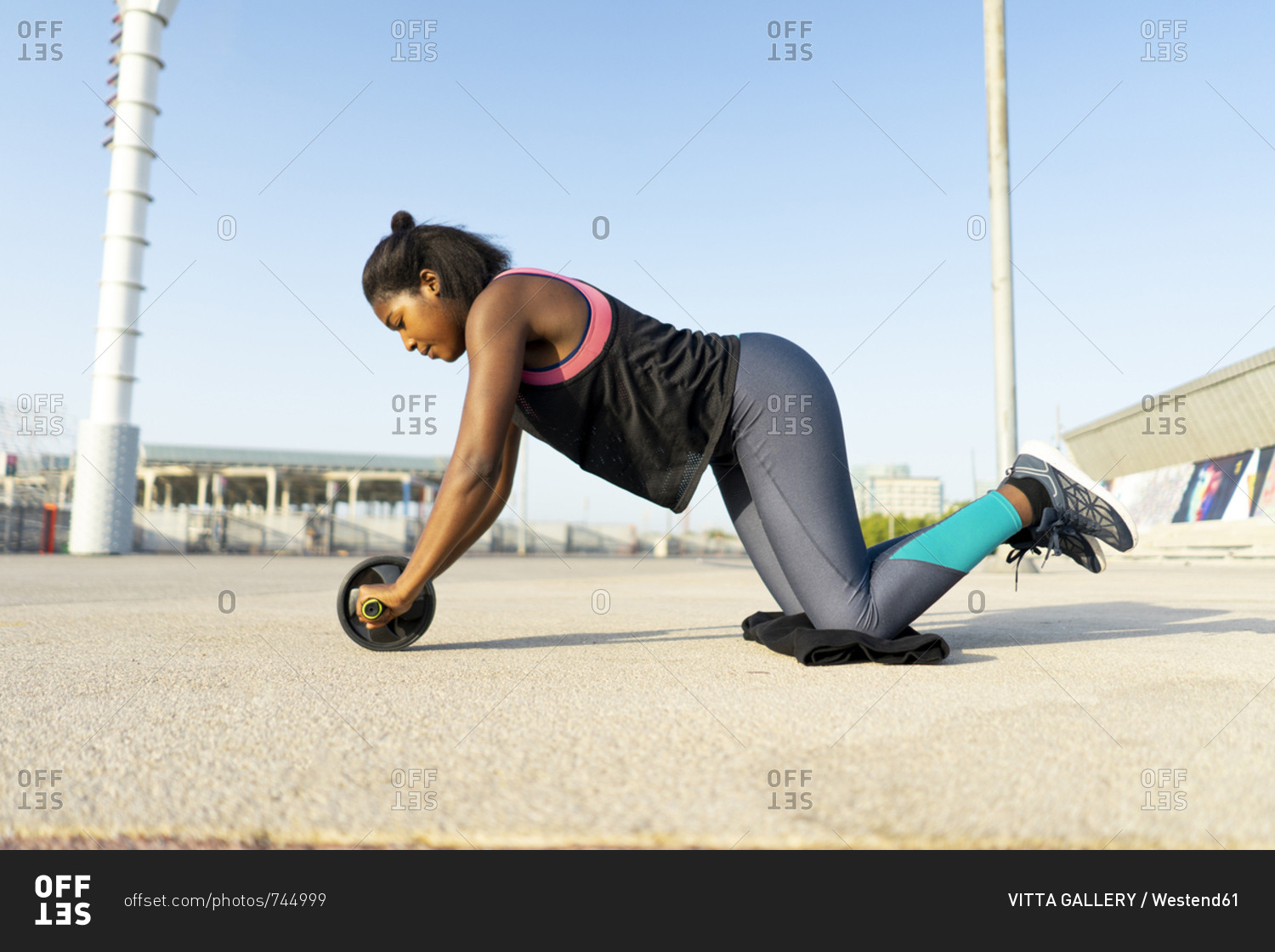 young sportive woman training with an ab wheel