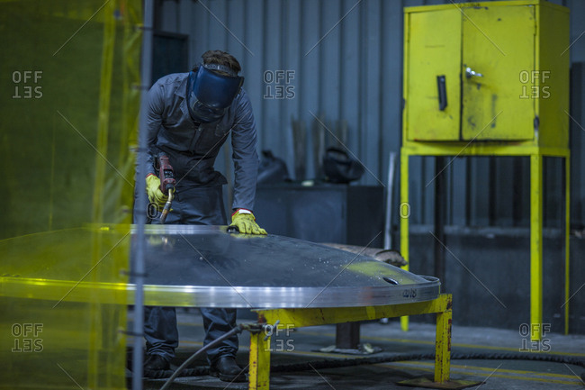 Worker welding in factory