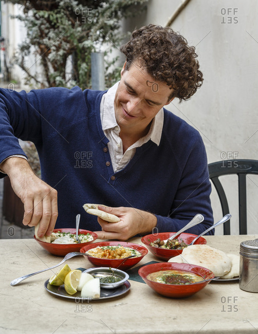 Jaffa, Tel Aviv, Israel - December 13, 2015: Man eating hummus at Shlomo and Doron Hummus place in the Carmel Market