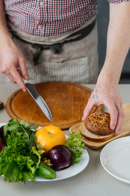 Man slicing buns for burgers