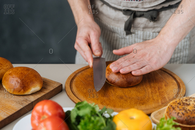 Man cutting buns for burgers