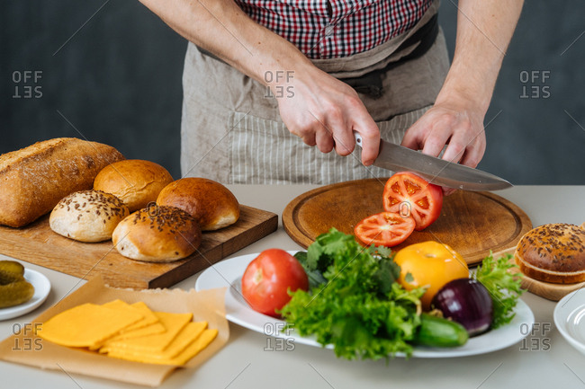 Chef cutting tomatoes for burgers