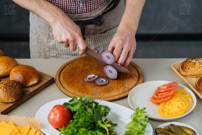 Man cutting onion for burgers