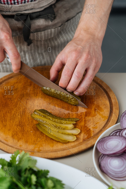 Chef slicing pickles for burgers