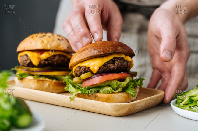 Chef placing bun on a cheeseburger