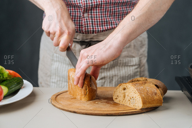 Man slicing bread for sandwich
