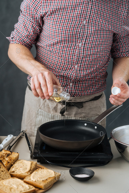 Man pouring oil into frying pan