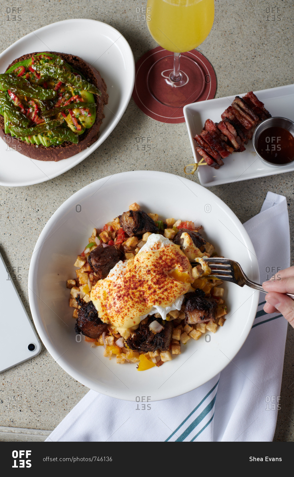 Pulled pork hash over small cut potatoes with poached eggs and a hollandaise sauce on top. On