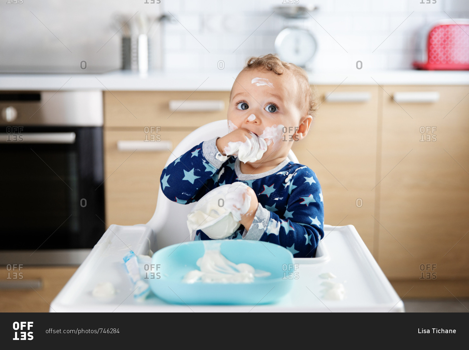 baby-making-mess-while-eating-yogurt-stock-photo-offset