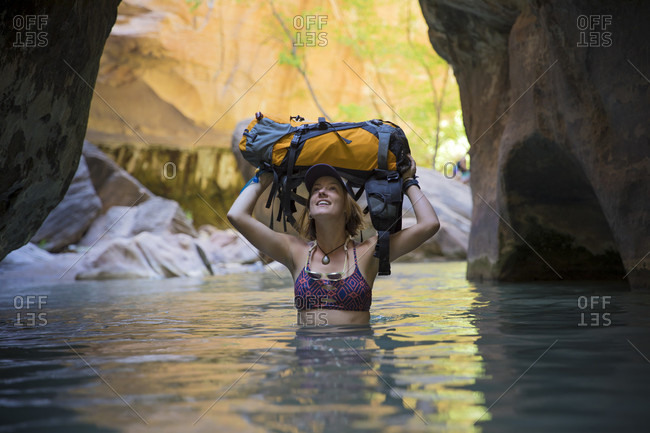 A woman explores the Narrows in Zion National Park, Utah.