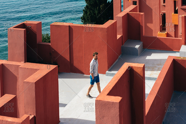 Man walking in a colorful geometric building roof terrace