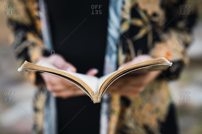 Close-up of paper notepad in hands of crop woman in daylight