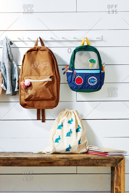 Personalized school bags hanging on wall-mounted rack