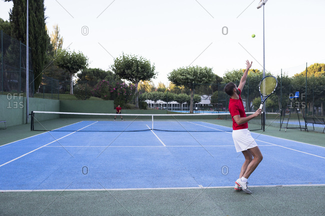 Man throwing up ball and aiming for it while playing tennis