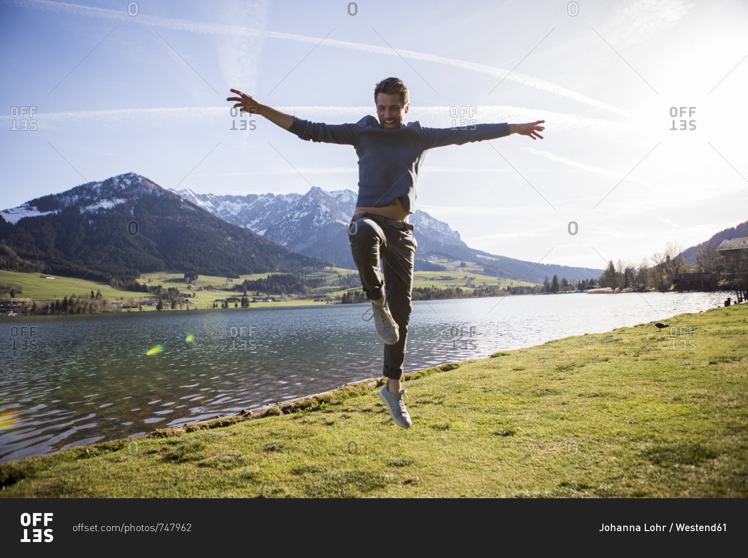 Austria- Tyrol- Walchsee- happy man jumping at the lake