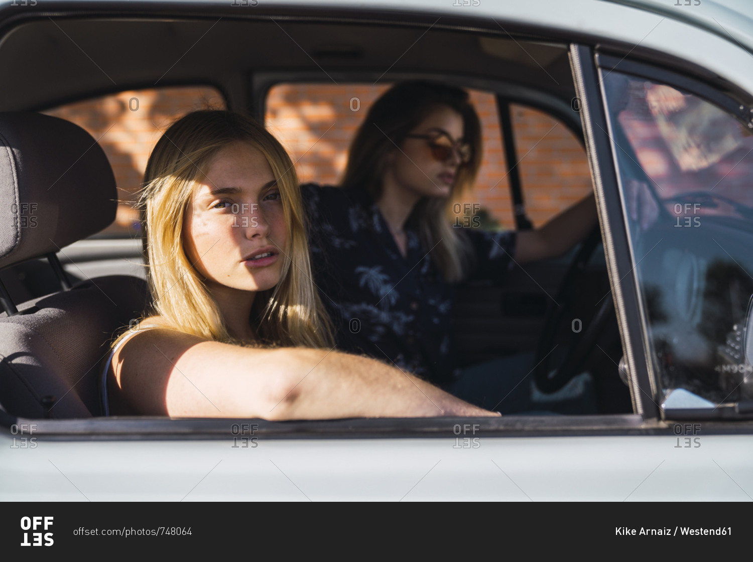 Portrait of young woman sitting in a car with friend
