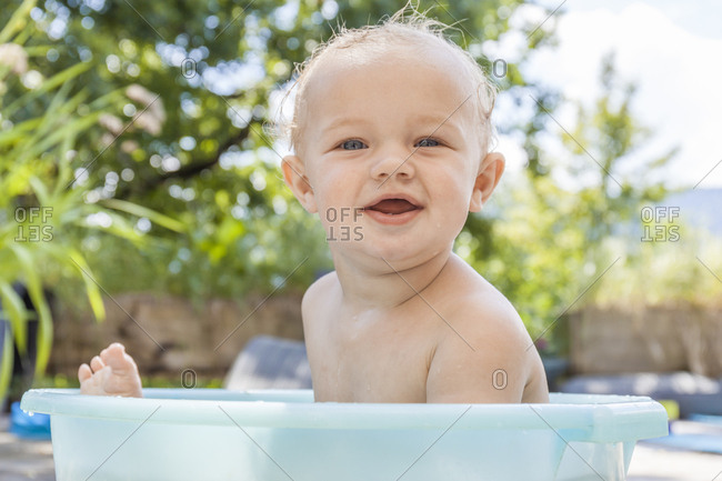 Boy sitting in baby bathtub