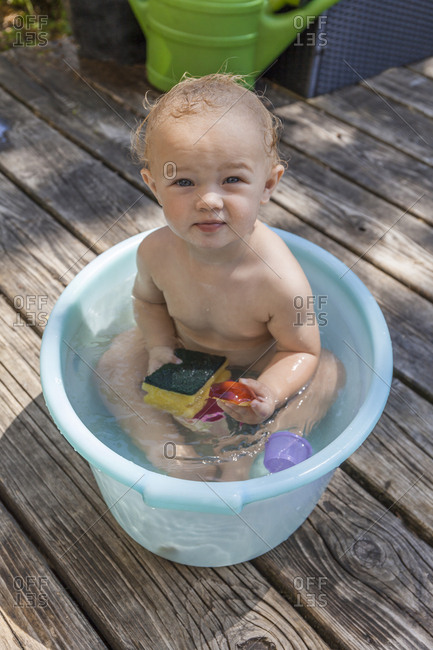Boy sitting in baby bathtub