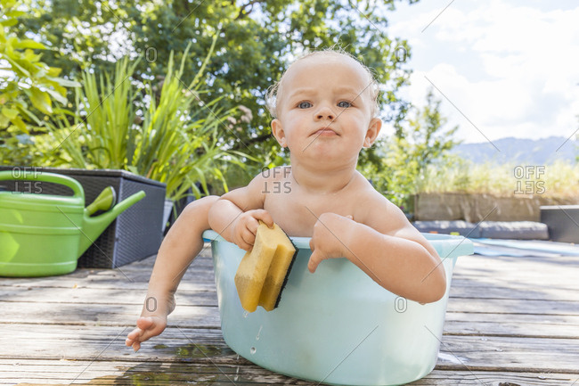Boy sitting in baby bathtub
