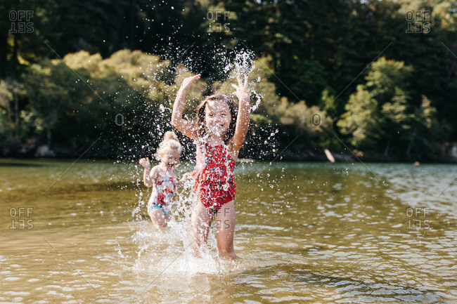 Girls playfully splashing in river together