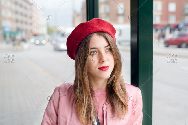 Young woman wearing red beret at bus stop