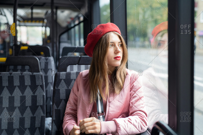 Young woman wearing red beret riding bus