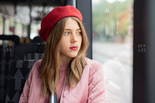 Young woman wearing red beret riding a bus