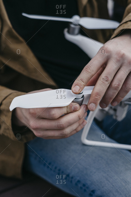 Close up of guy putting on screws on a drone before taking it on a flight