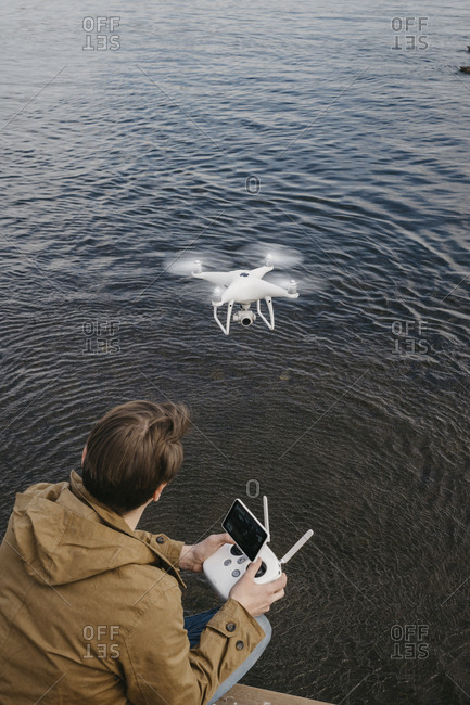 Young man looking up at his drone as it flies by