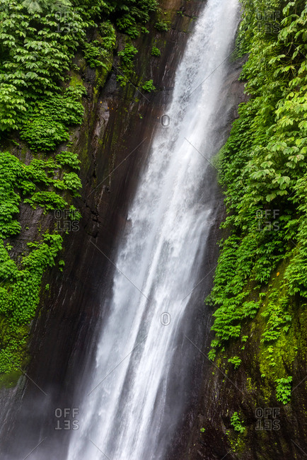 Woman in front of a waterfall in Bali, Indonesia