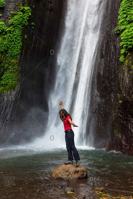 Woman in front of a waterfall in Bali, Indonesia