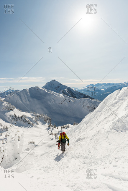 Skier walking with ski board on a snowy mountain during winter