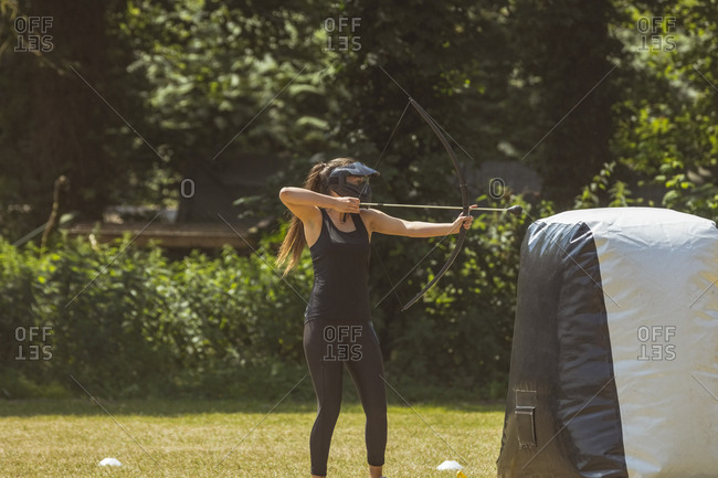 Woman practicing archery at boot camp on a sunny day