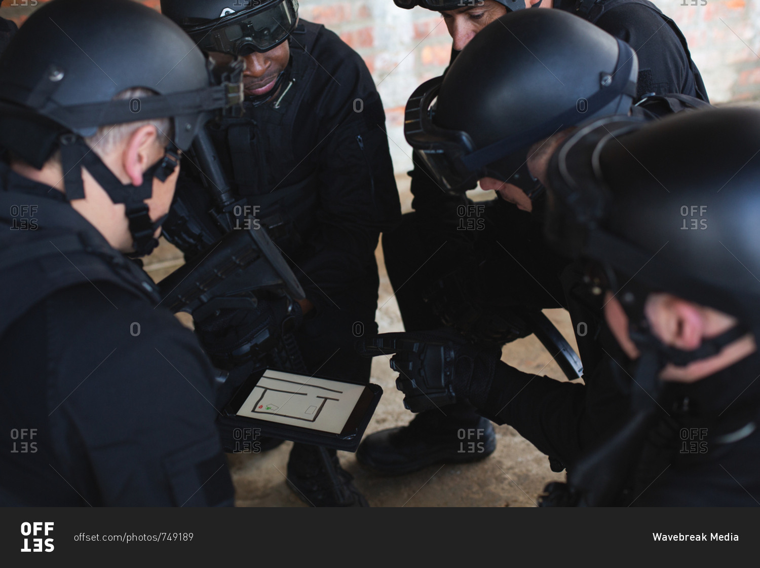 Military soldiers discussing their plan over digital tablet during military training