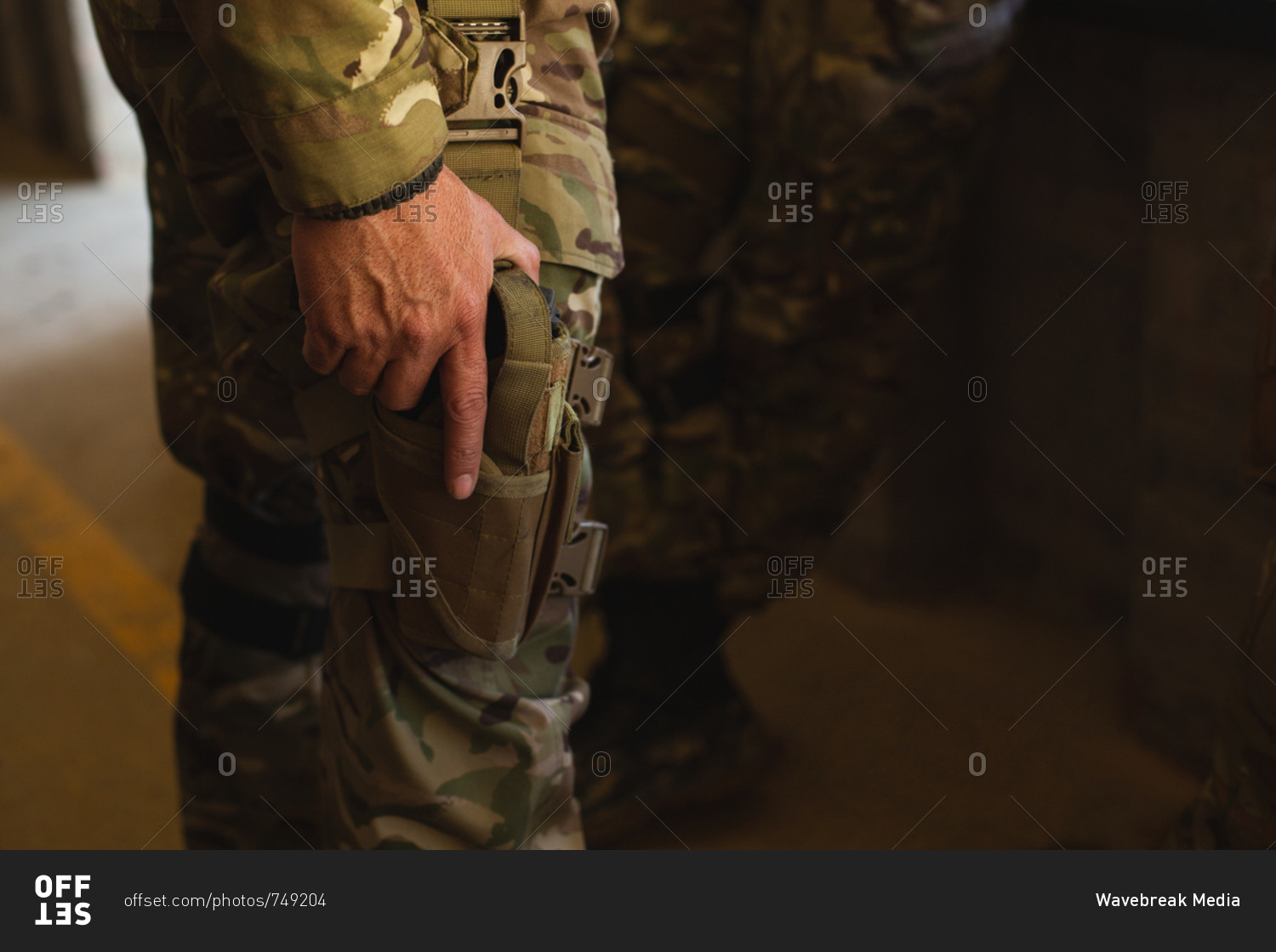 Mid section of military soldier standing with pistol during military training