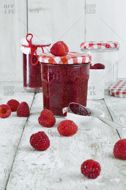 Jars of raspberry jam and raspberries