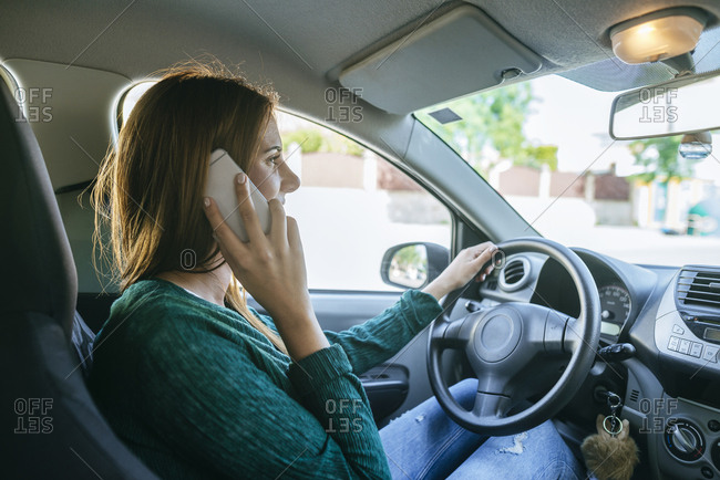 Woman talking on the mobile phone inside of a car