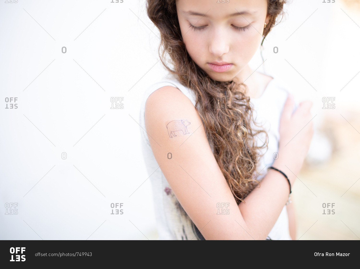 Young girl looking at a temporary tattoo on her forearm