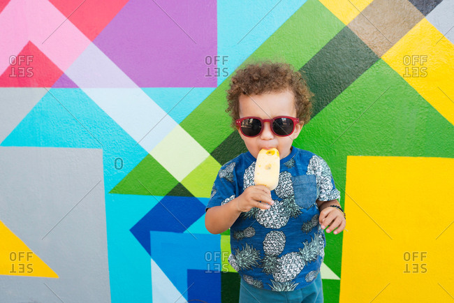 Toddler eating ice cream, mural in background, Wynwood, Miami, Florida, USA