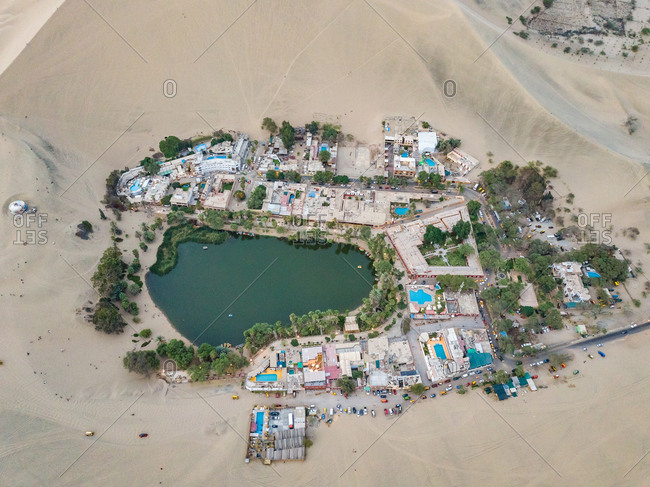 Aerial close up of Huacachina desert oasis resorts and swimming pools, Peru