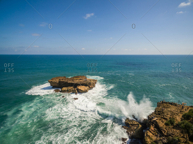 Aerial view of rock formation in sea and fishermen off Timang Beach, Yogyakarta, Indonesia