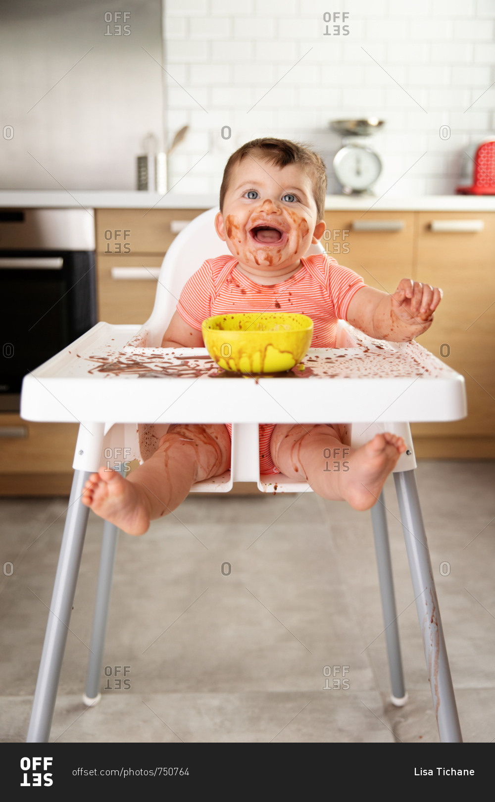 Happy baby making mess while eating pudding