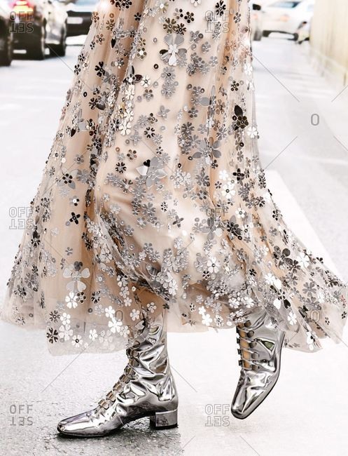 Paris, France - September 21, 2018: Woman wearing shiny boots and floral skirt